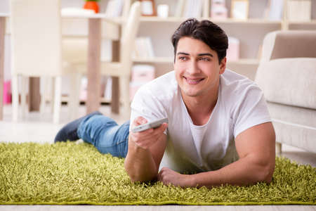 Man watching tv at home on floorの写真素材