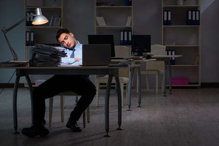 Employee working late at night at important reportの写真素材