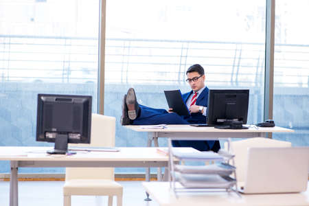 Young handsome businessman employee working in office at deskの写真素材