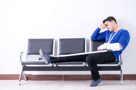 Desperate man waiting for his appointment in hospital with brokeの写真素材