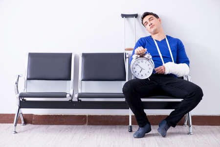 Desperate man waiting for his appointment in hospital with brokeの写真素材