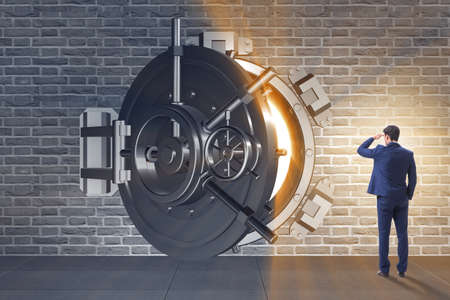 Businessman in front of banking vault doorの写真素材