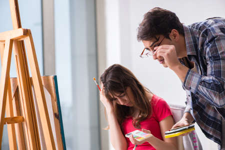 Artist coaching student in painting class in studioの写真素材