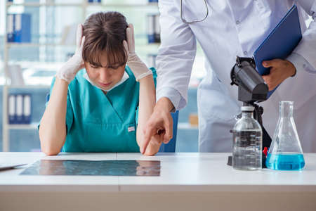 Doctor angry at his assistant due to medical errorの写真素材