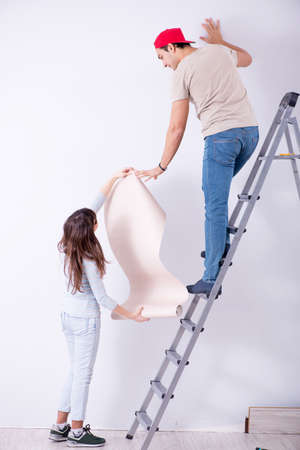 Young family doing renovation at home with new wallpaperの写真素材