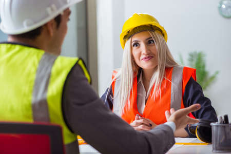 Construction workers having discussion in office before startingの写真素材