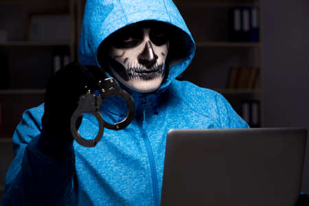 Scary hacker hacking security firewall late in office