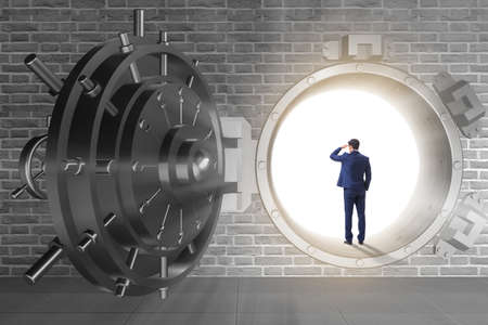 Businessman in front of banking vault doorの写真素材