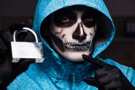 Scary hacker hacking security firewall late in officeの写真素材