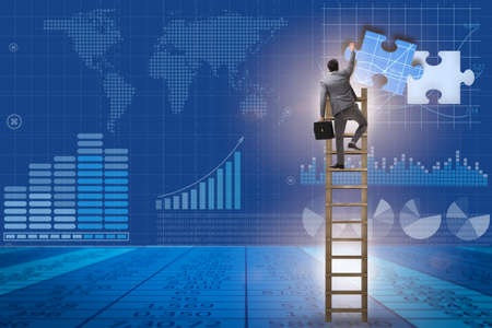 Businessman putting together jigsaw puzzle piecesの写真素材