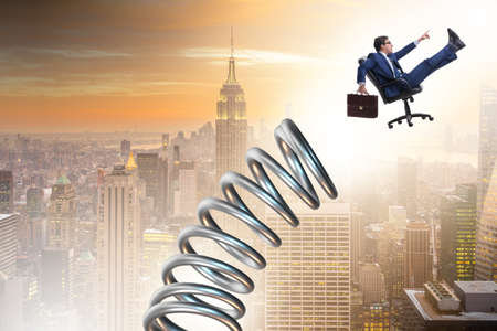 Businessman jumping from spring in promotion conceptの写真素材