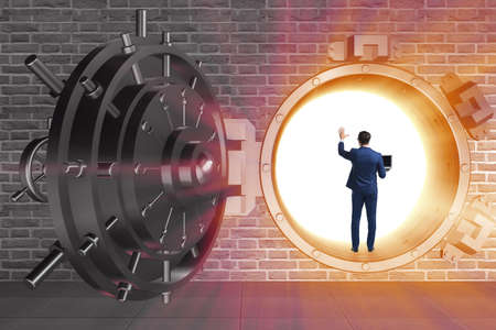 Businessman in front of banking vault doorの写真素材