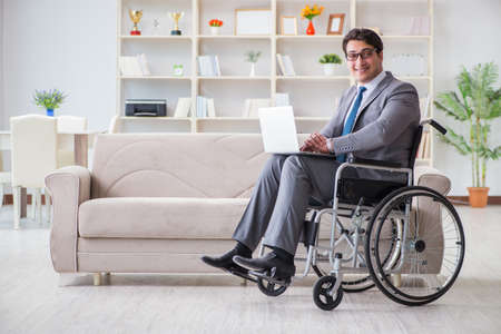 Dsabled businessman on wheelchair working homeの写真素材