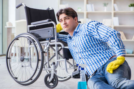 Disabled man on wheelchair cleaning homeの写真素材