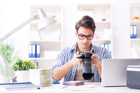 Young photographer working with his cameraの写真素材