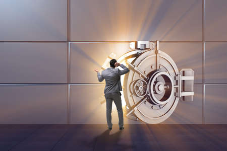 Businessman concerned about theft at banking vault doorの写真素材