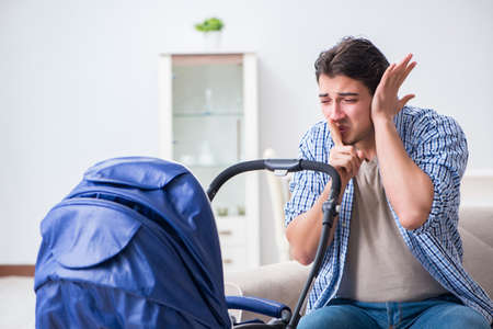 Young father looking after newborn baby at homeの写真素材