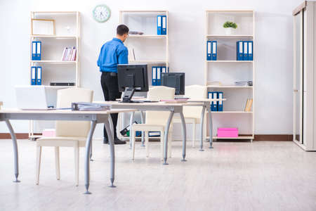 Handsome businessman employee sitting at his desk in officeの写真素材