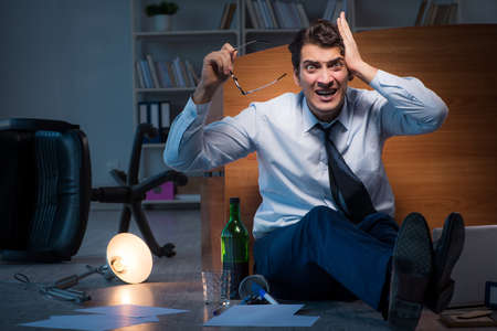 Stressed businessman working overtime in depressionの写真素材