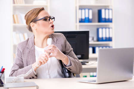 Businesswoman employee talking on the office phone