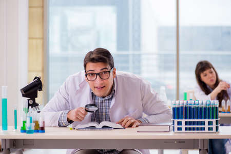 Two chemists working in lab experimentingの写真素材