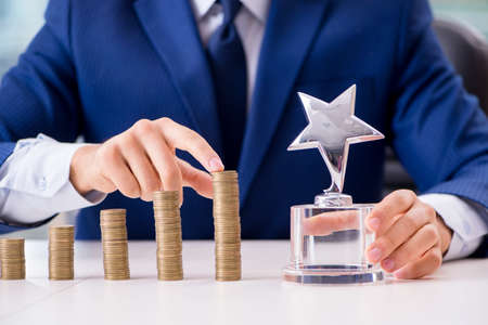 Businessman with stacks of coins in the officeの写真素材