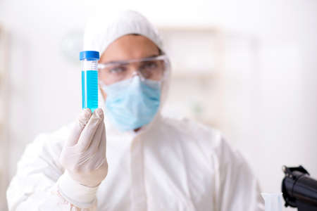 Young chemist student working in lab on chemicals