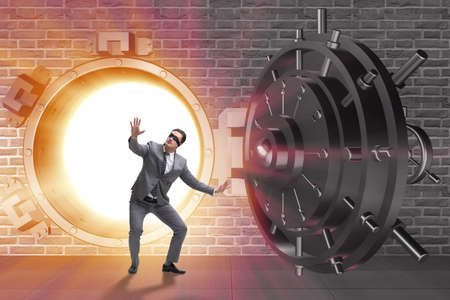Businessman in front of banking vault doorの写真素材