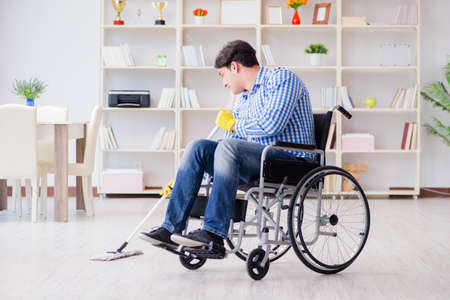 Disabled man on wheelchair cleaning homeの写真素材