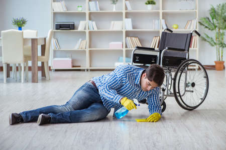 Disabled man on wheelchair cleaning homeの写真素材