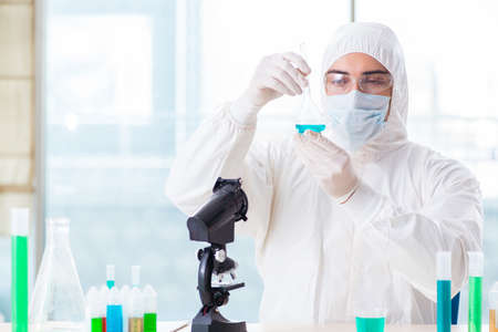 Young chemist student working in lab on chemicalsの写真素材