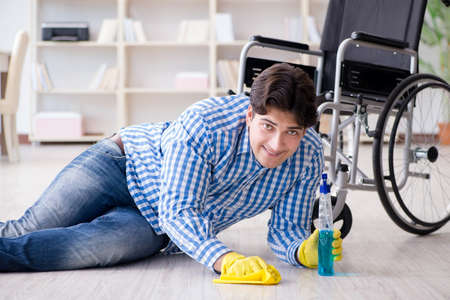 Disabled man on wheelchair cleaning homeの写真素材