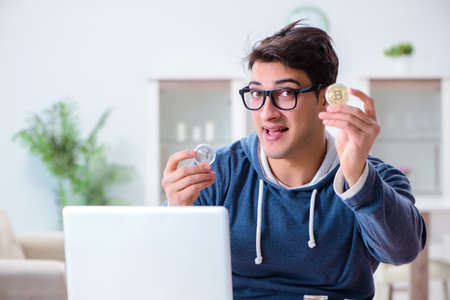 Young man mining bitcoins at homeの写真素材