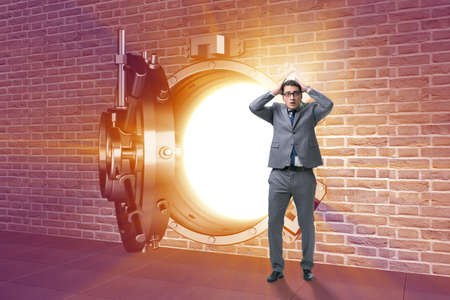 Businessman in front of banking vault doorの写真素材