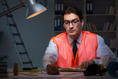 Construction architect working on drawings late at night