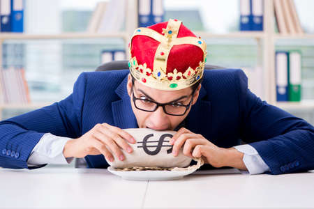 King businessman with money sack in officeの写真素材