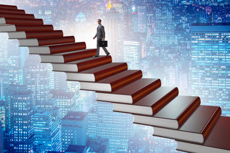 Businessman student climbing the ladder of education booksの写真素材
