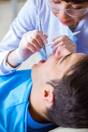 Woman dentist doctor with male patient in hospitalの写真素材