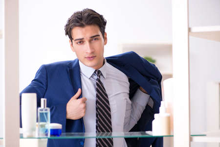 Man is getting dressed up for work in bathroomの写真素材