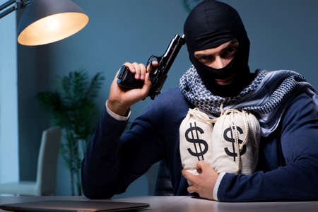 Terrorist burglar with gun asking for money ransomの写真素材