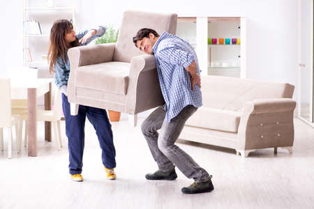 Man moving armchair in the living roomの写真素材