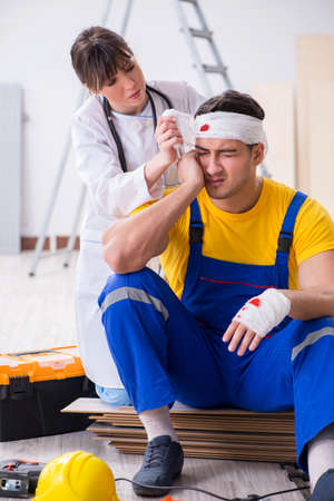 Worker with injured head and doctorの写真素材