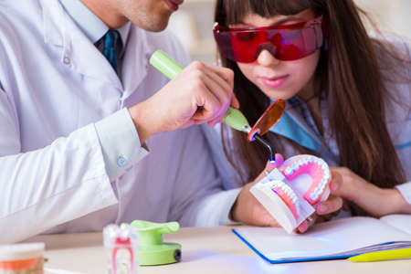 Doctor explaining to assistant how to use ultraviolet gunの写真素材