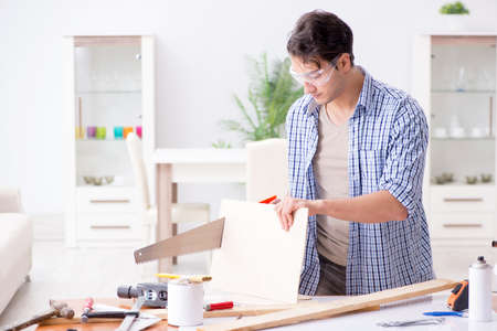 Young man in woodworking hobby conceptの写真素材