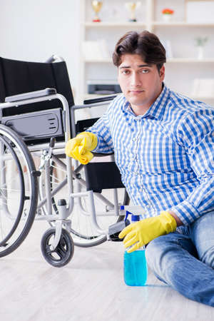 Disabled man on wheelchair cleaning homeの写真素材