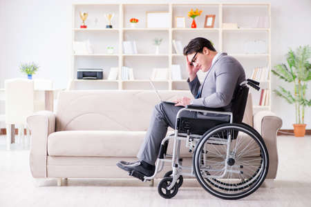 Dsabled businessman on wheelchair working homeの写真素材