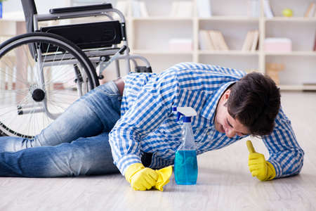 Disabled man on wheelchair cleaning homeの写真素材
