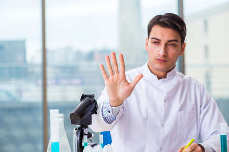 Young chemist pressing virtual buttons in labの写真素材