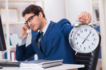Businessman employee in urgency and deadline concept with alarmの写真素材