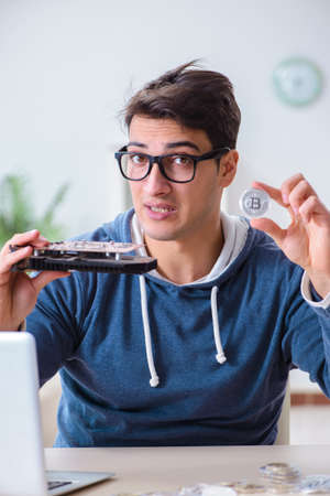 Young man mining bitcoins at homeの写真素材